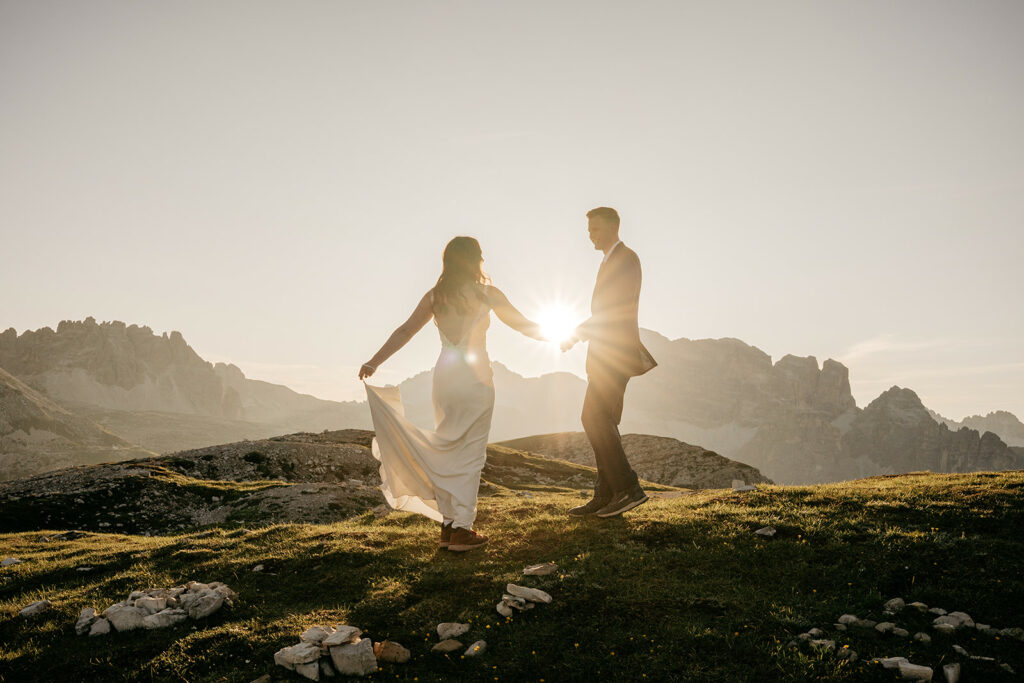 Couple dancing on mountain at sunset.