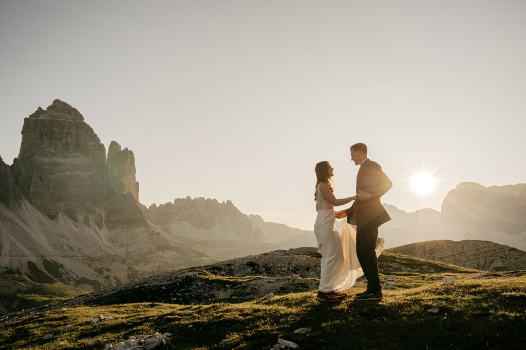 Couple embraces at sunset in mountain landscape.