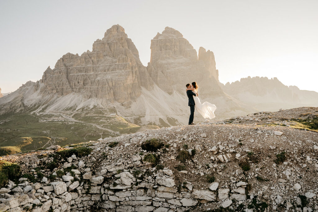 Couple embracing in mountain landscape at sunset.