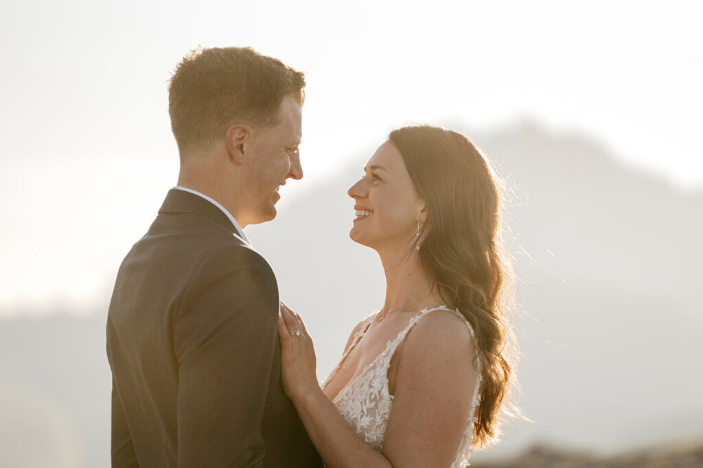 Couple smiling at sunset on wedding day.