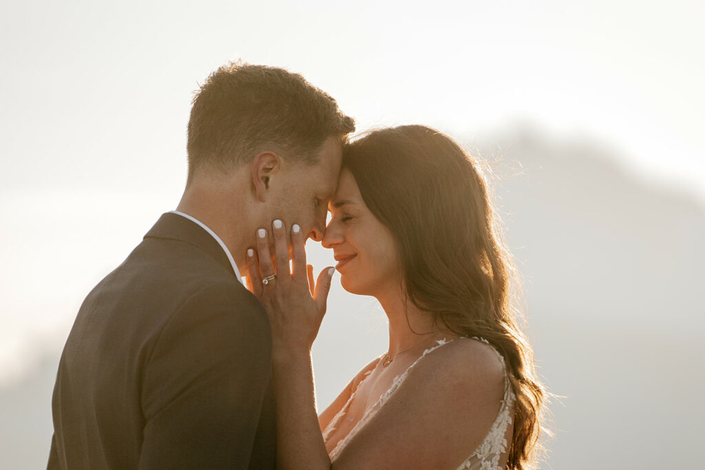 Couple embracing at sunset in formal attire.