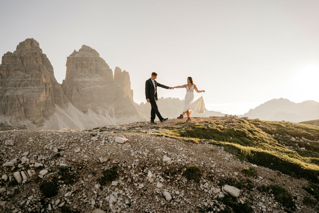 Couple dancing on mountain at sunrise.