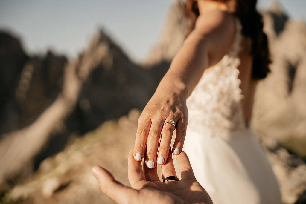Bride holding hand in mountain landscape