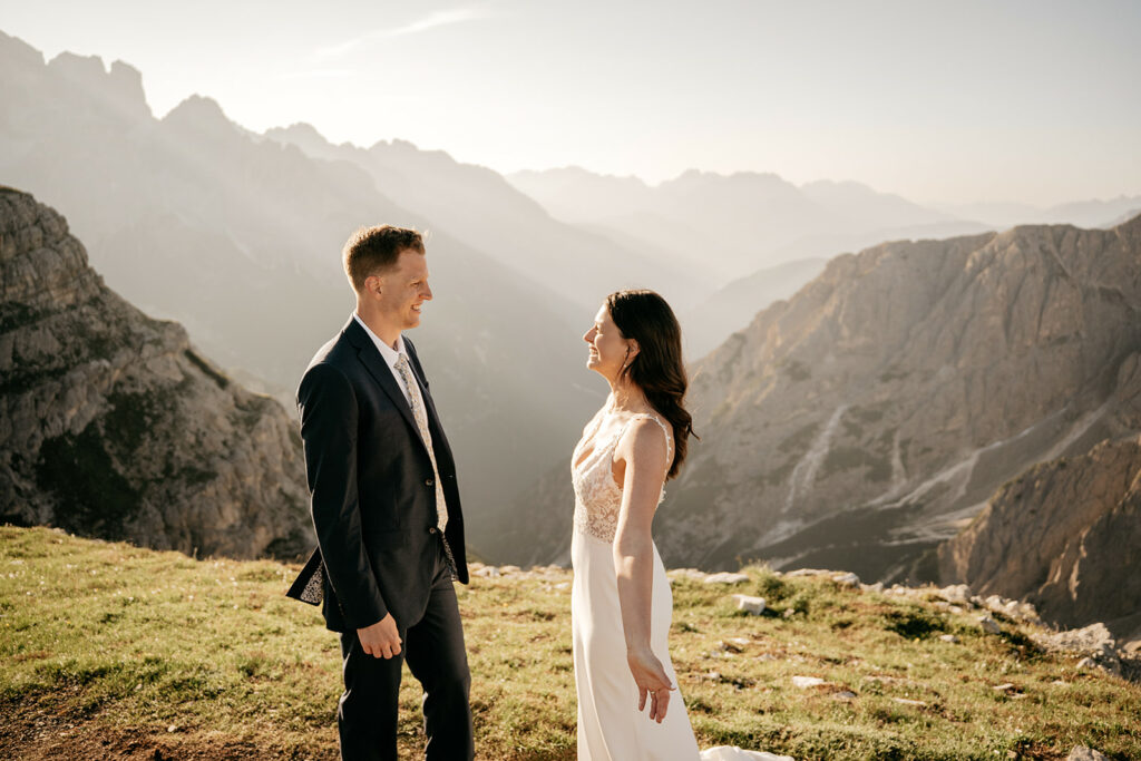 Couple standing on mountain during sunny day