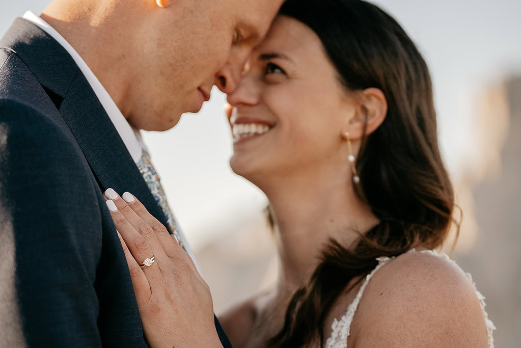 Close-up of a couple embracing, showing engagement ring.