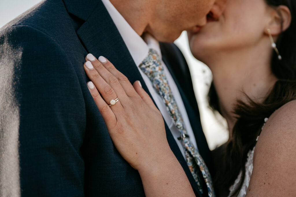 Close-up of couple embracing, focus on engagement ring.