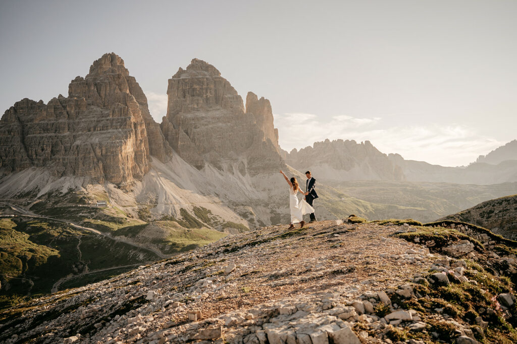 Couple dancing on mountain with rocky peaks background.