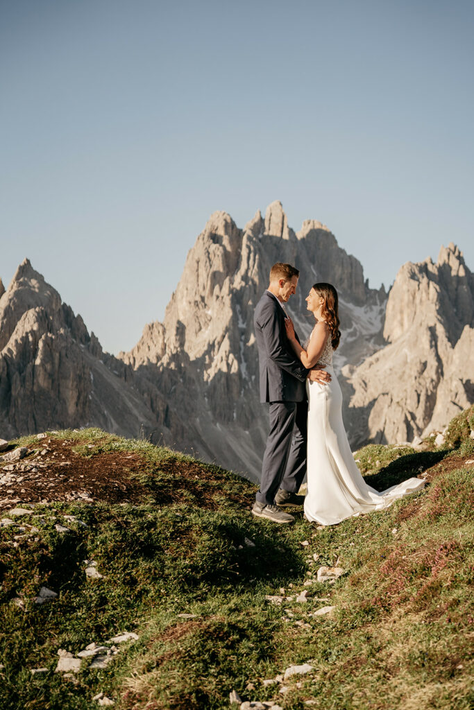 Bride and groom in front of mountain backdrop.