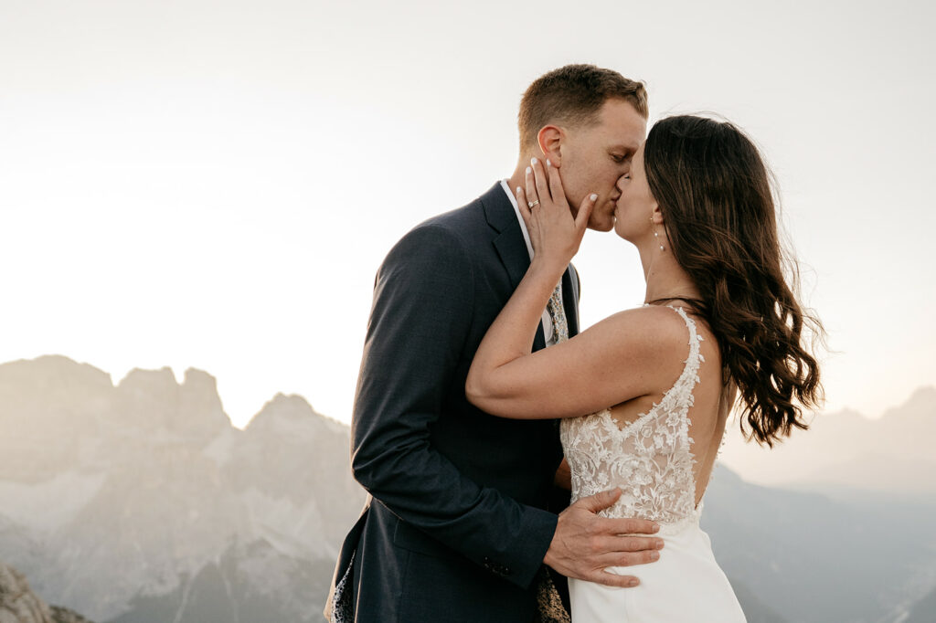 Bride and groom kissing in mountain scenery