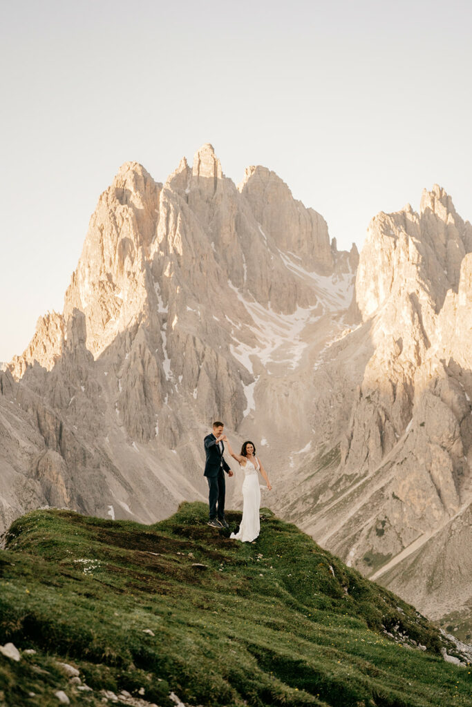 Couple on mountain cliff in wedding attire