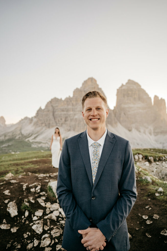 Man in suit, woman in wedding dress, mountain backdrop