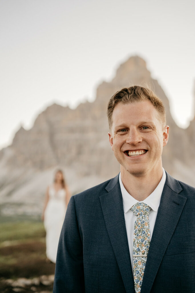Smiling groom with bride in scenic mountain background