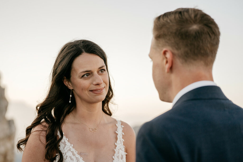 Bride and groom sharing a loving gaze outdoors.