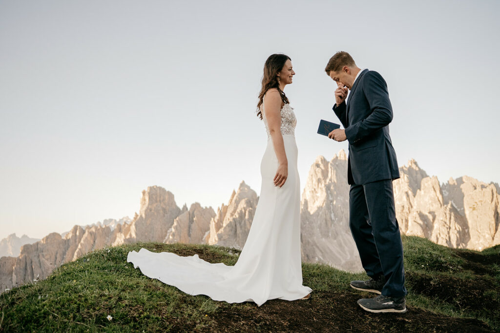 Couple exchanging vows in scenic mountain setting.