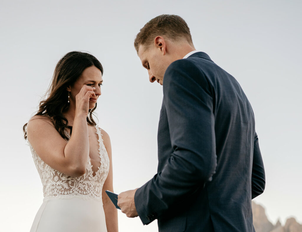 Couple exchanging vows outdoors at sunset.