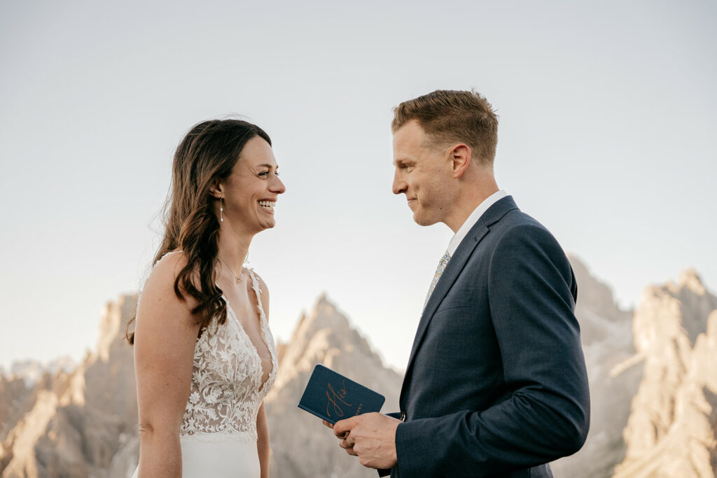 Couple exchanging vows in mountain ceremony.