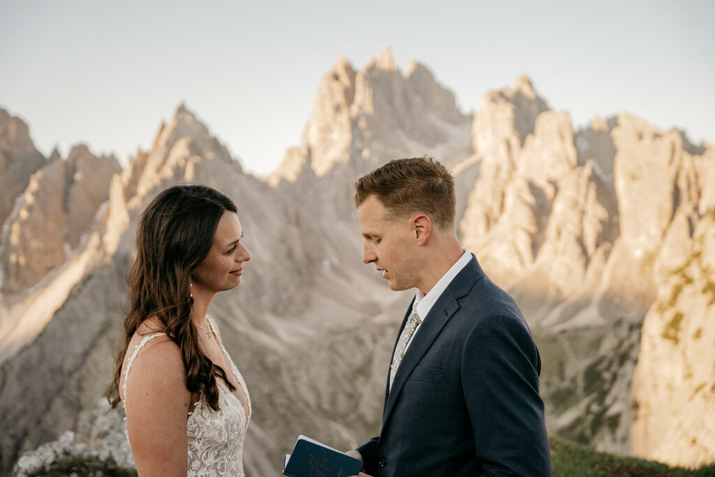 Couple exchanging vows in mountain landscape.