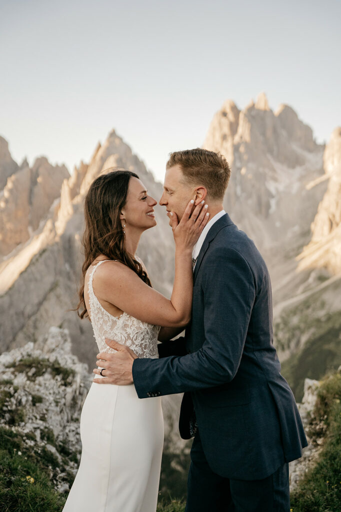 Bride and groom embrace in mountain landscape
