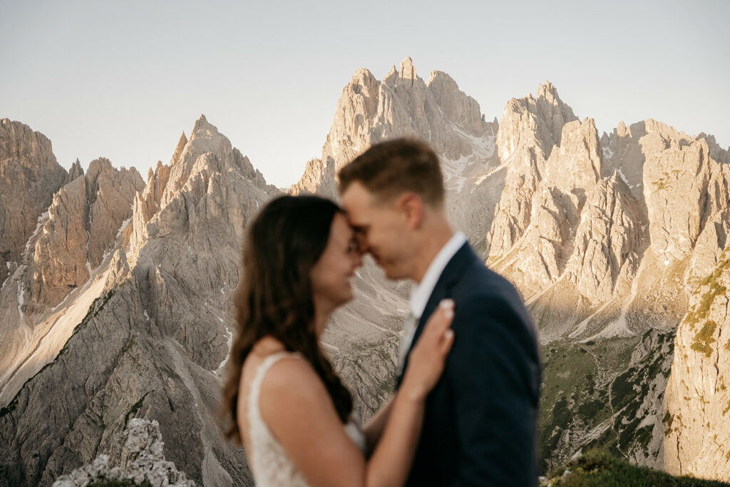 Couple embracing with mountains in the background.