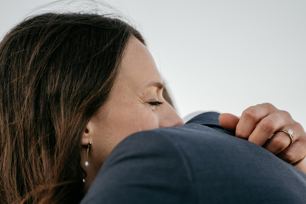 Woman hugging person, wearing gold ring