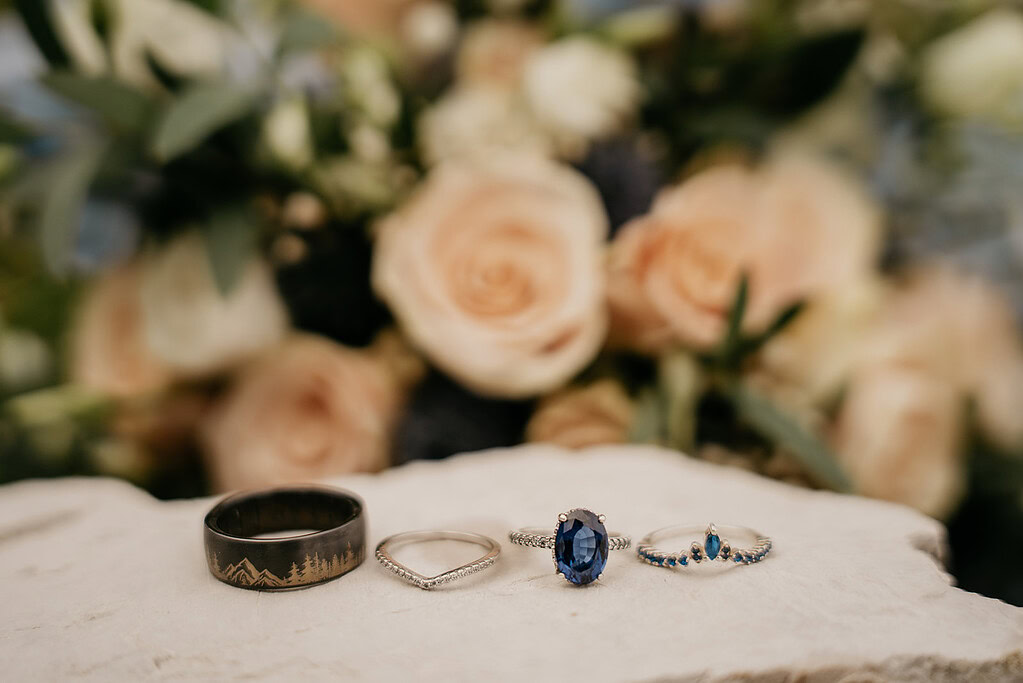 Elegant rings on display with roses behind.