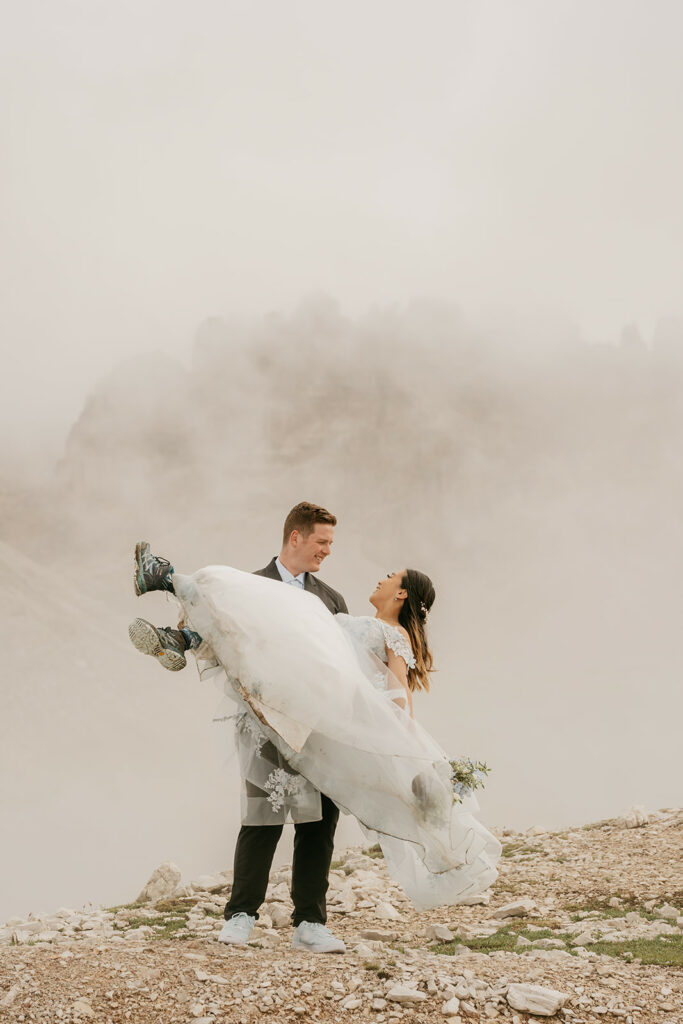 Bride and groom on misty mountain wedding day.