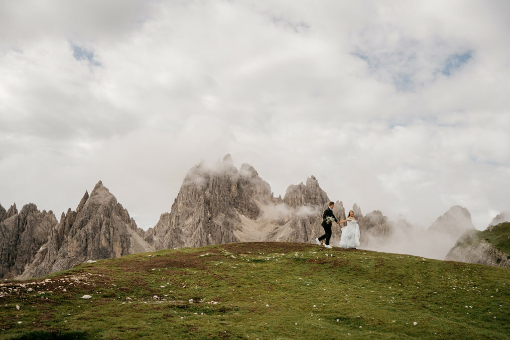 Couple on mountain with misty peaks background.