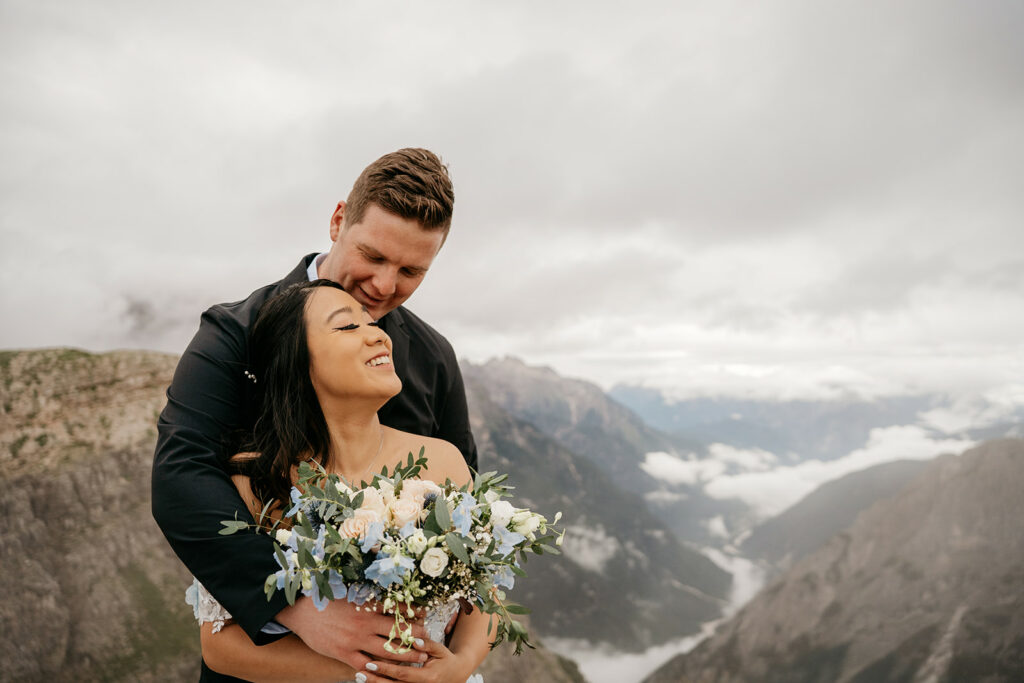 Couple embracing with mountain backdrop.