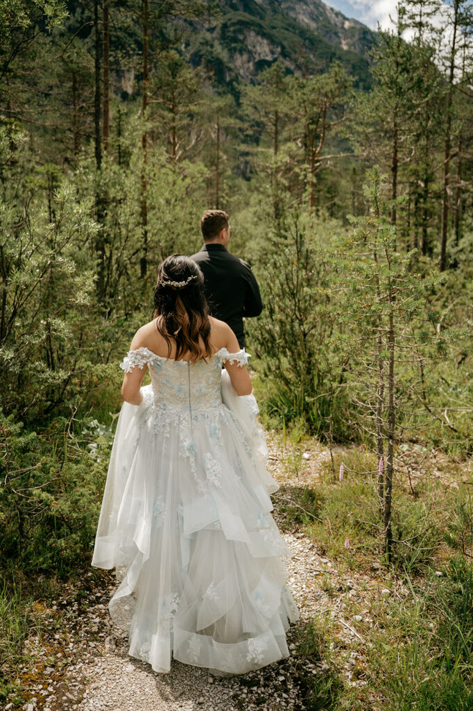 Bride and groom walking in forest trail