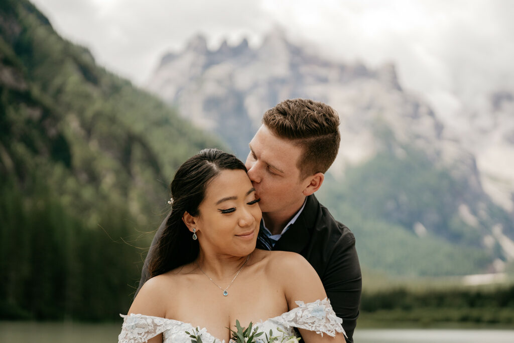 Couple embraces in scenic mountain backdrop.