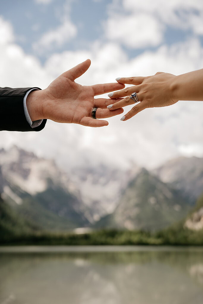 Couple holding hands, mountains in background.