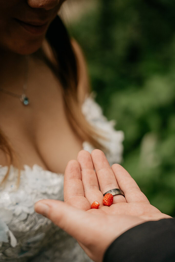 Person holding tiny strawberries in hand