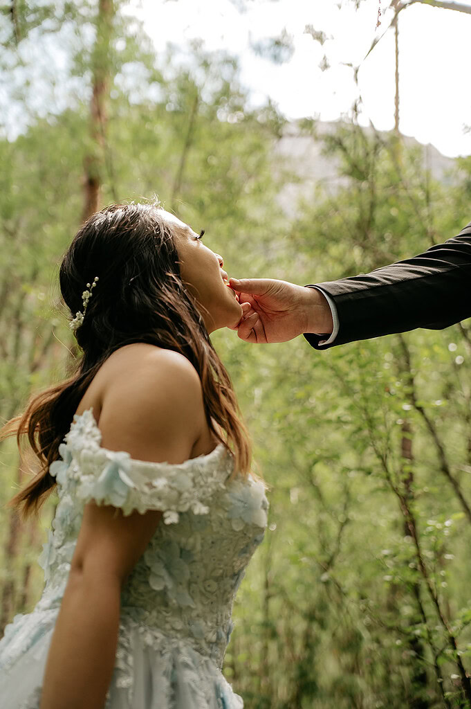 Bride in forest, hand touching chin