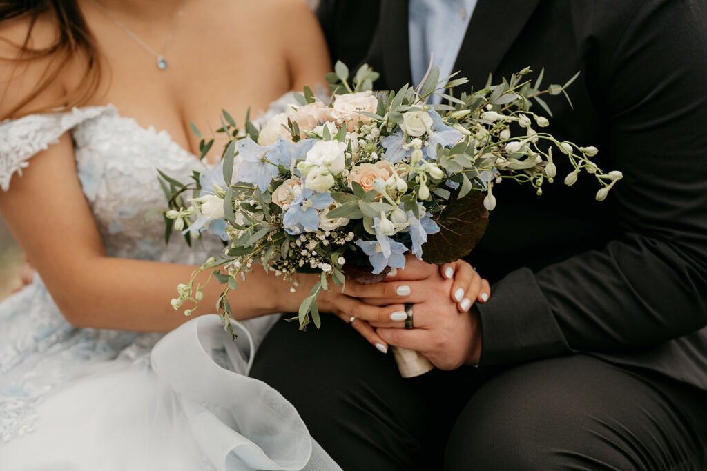 Bride and groom holding bouquet of flowers.