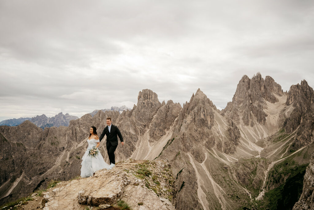 Couple walking on mountain during wedding photoshoot.
