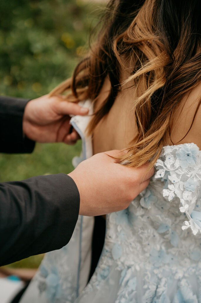 Person helping zip floral dress outdoors