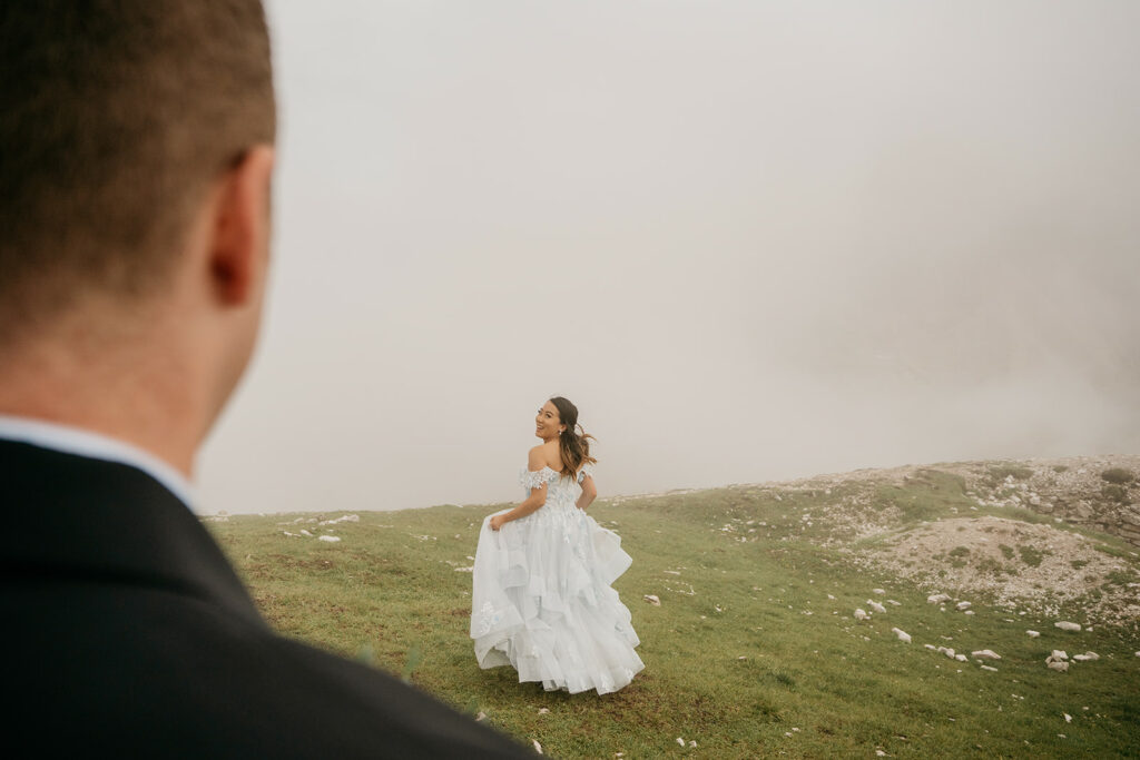 Bride in white dress on misty mountain