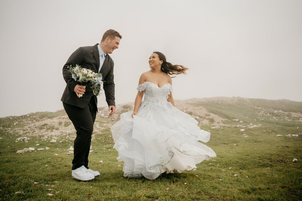 Bride and groom smiling outdoors on foggy day.