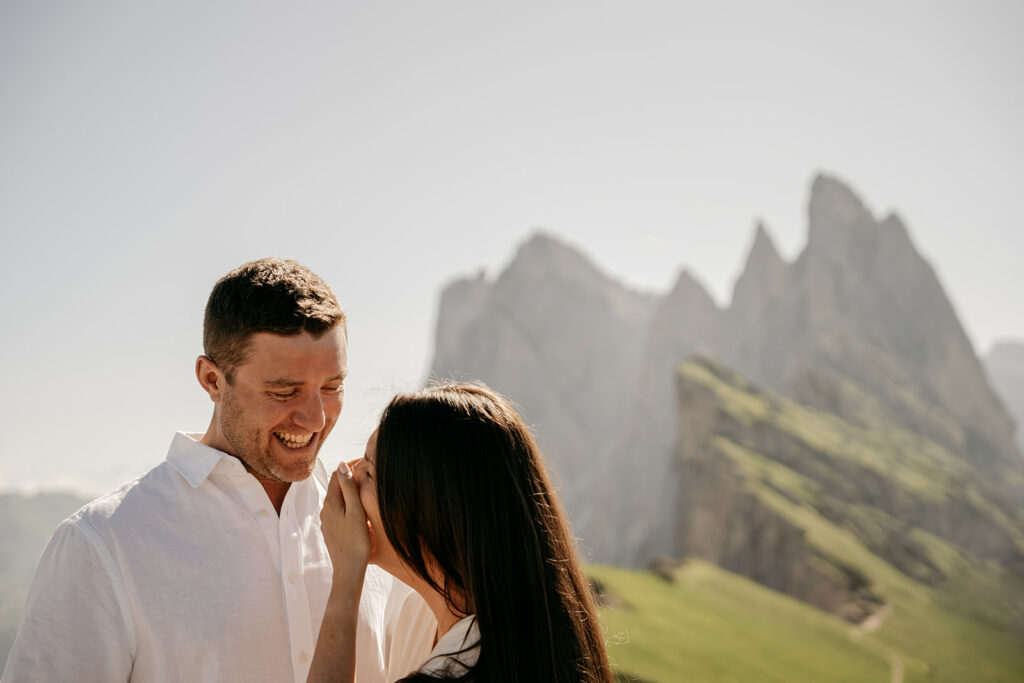 Couple laughing with mountain backdrop.