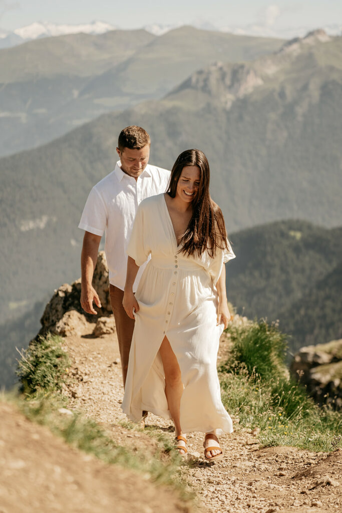 Couple hiking on mountain trail, enjoying nature.