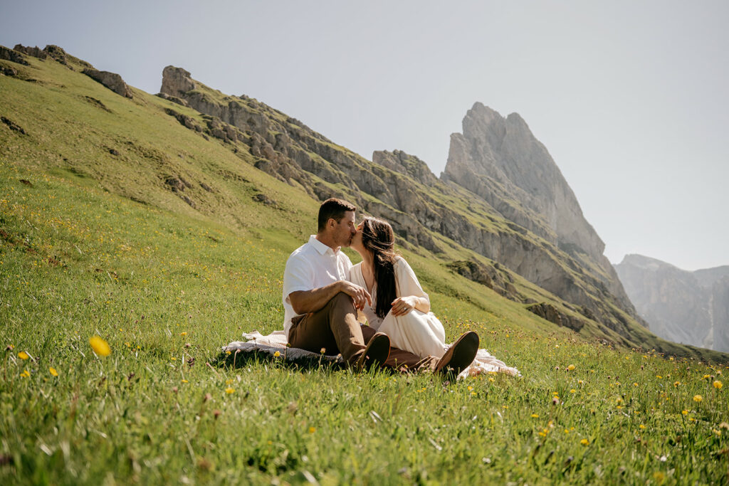 Couple kissing on grassy mountain field