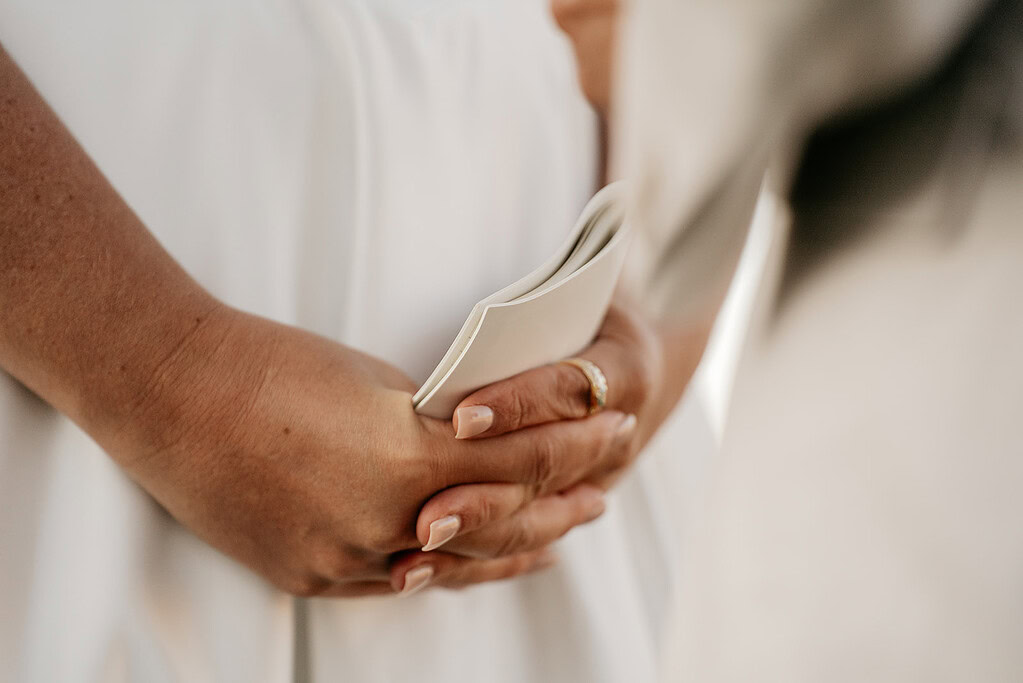 Person holding paper, close-up of hands.