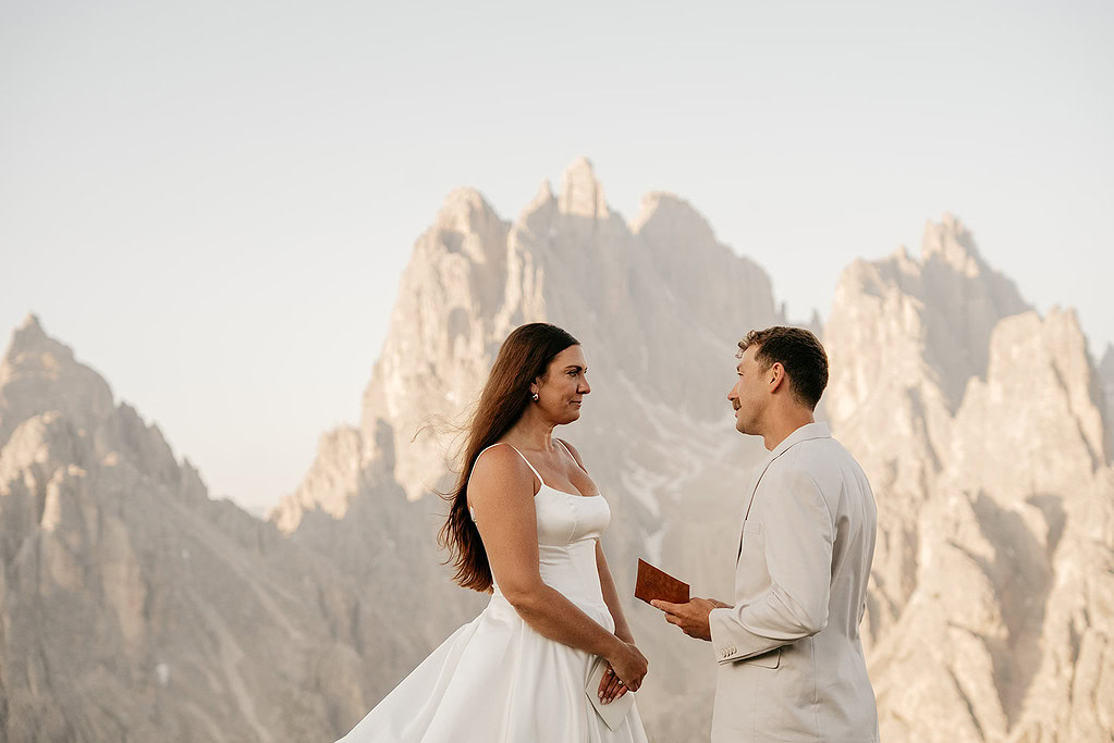 Couple exchanges vows in mountains, serene wedding setting.
