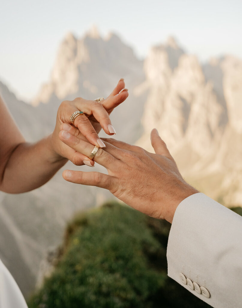 Couple exchanging rings with mountain background