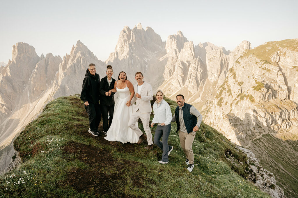 Group celebrating on mountain with scenic view.