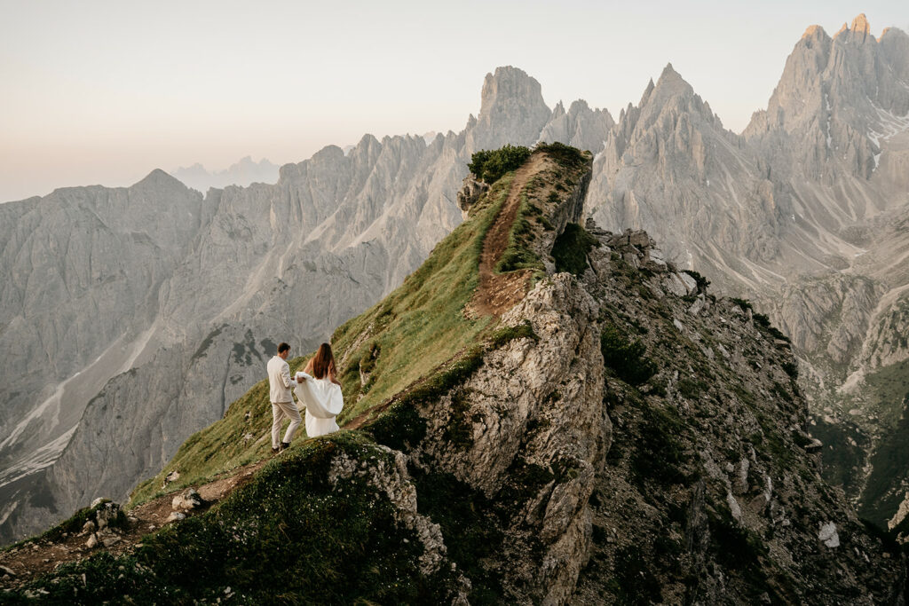 Couple walking on mountain ridge during sunset
