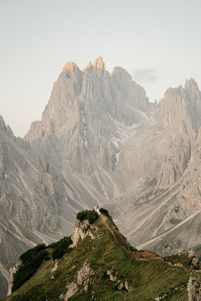 Couple on mountain peak with majestic views.