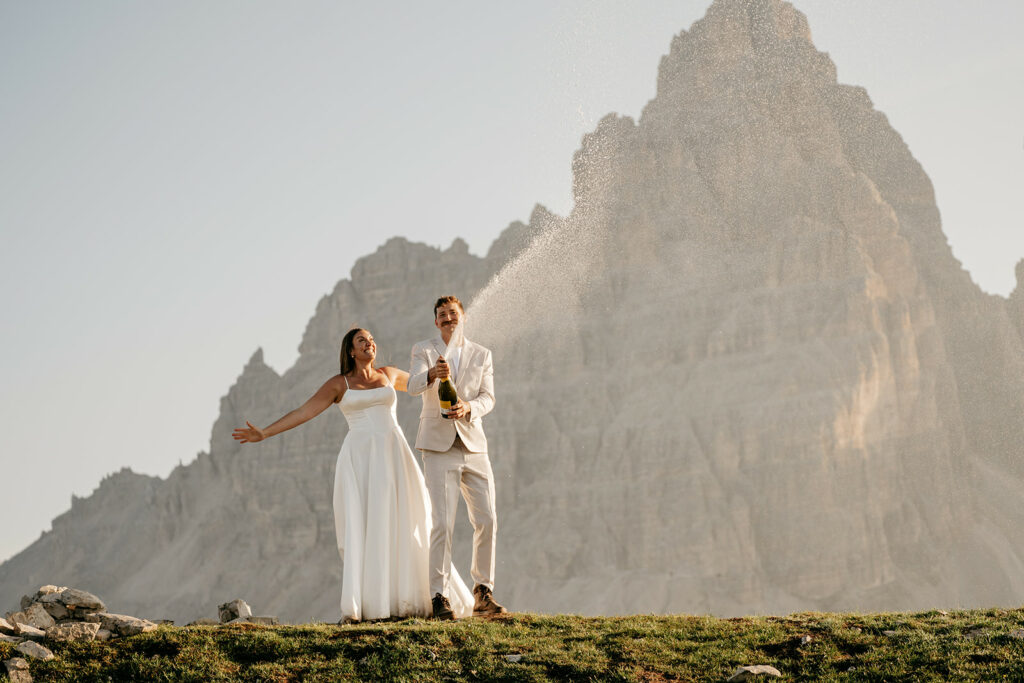 Couple celebrating with champagne on a mountain.
