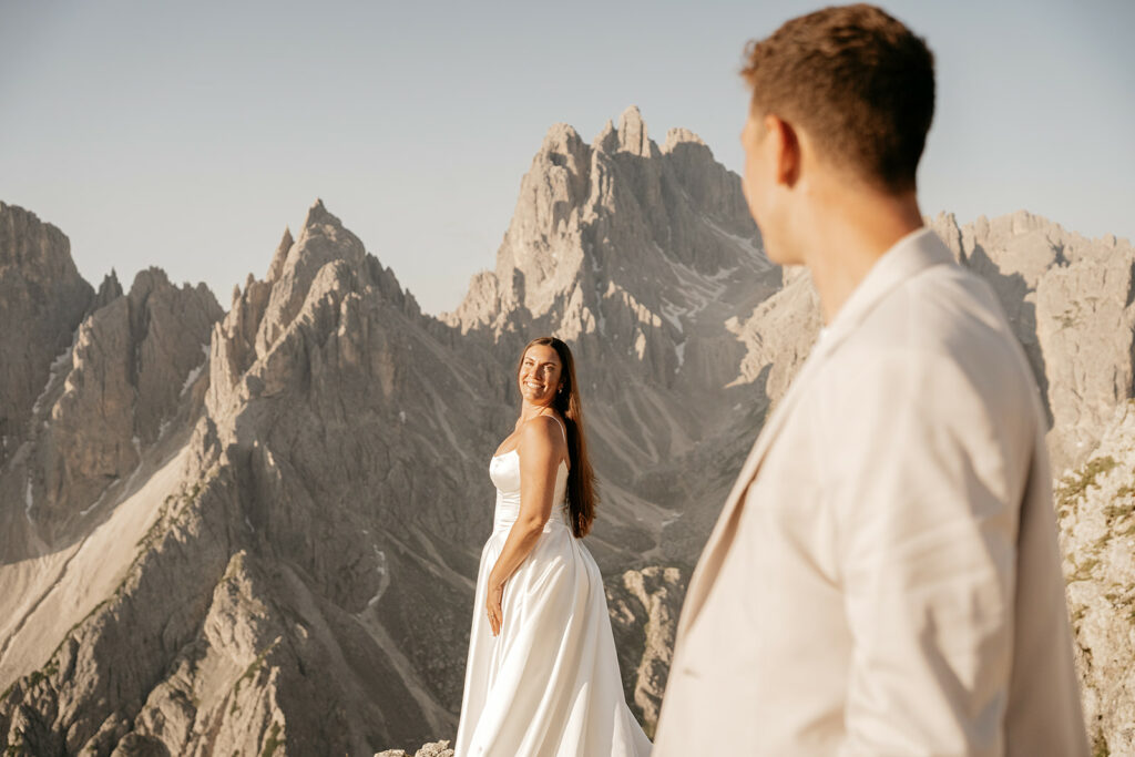 Bride and groom in mountain landscape, sunset.