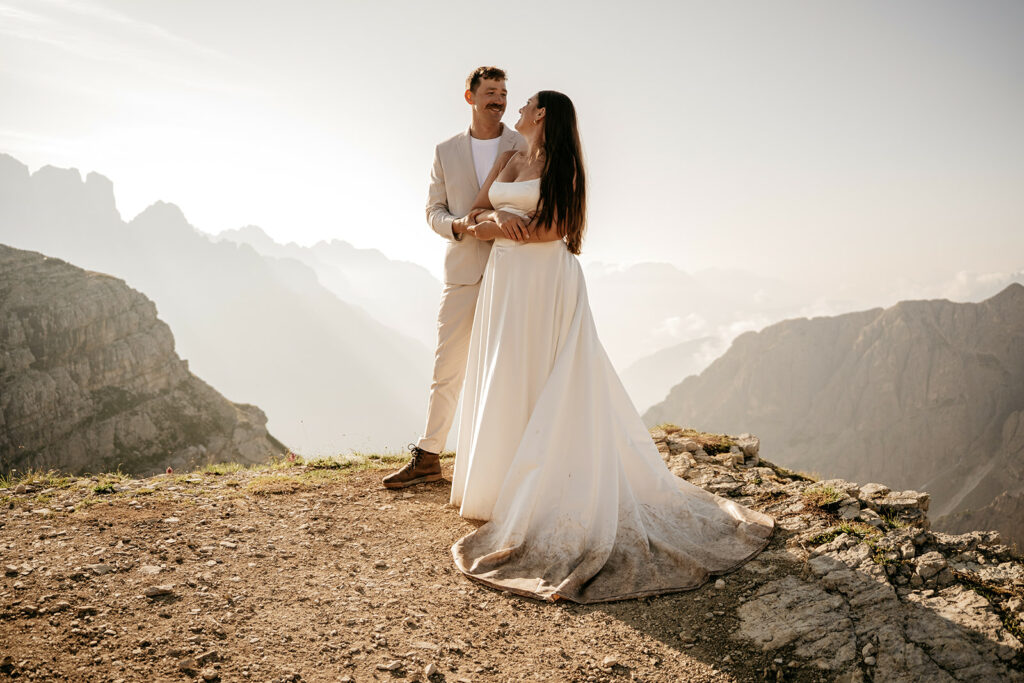 Couple embracing on mountain during their wedding.
